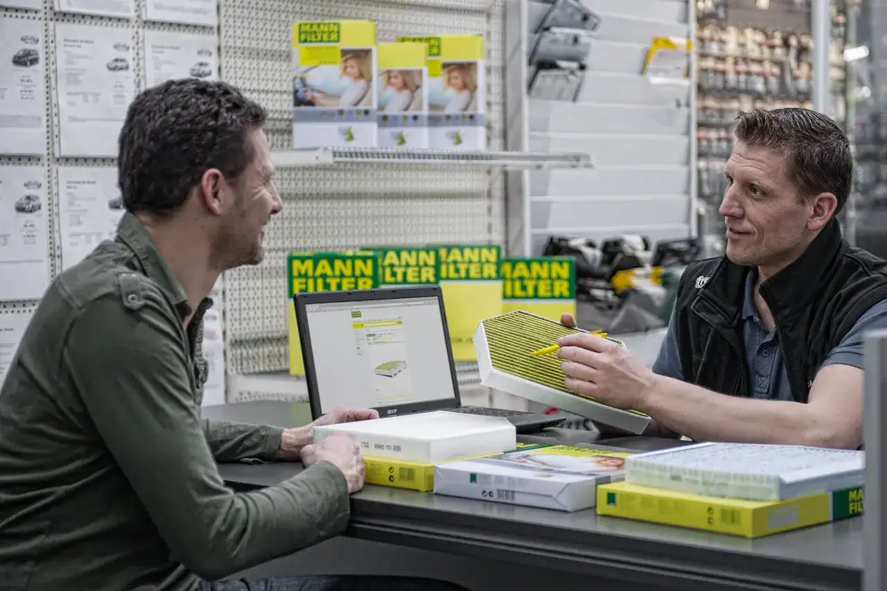 Ein Mann sucht mit Hilfe eines Mann-Ölfilter-Finders auf einem Laptop nach dem passenden Filter.