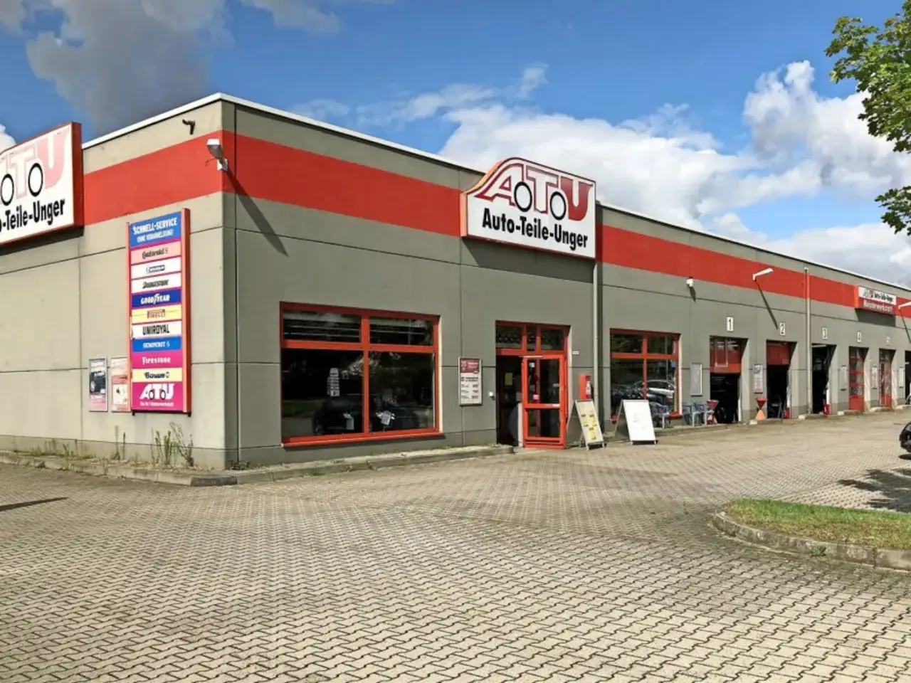 ATU Auto-Teile-Unger in Köln: ein Geschäft mit roten Akzenten und vielen Garagentoren für schnelle Reparaturen und Ersatzteile.