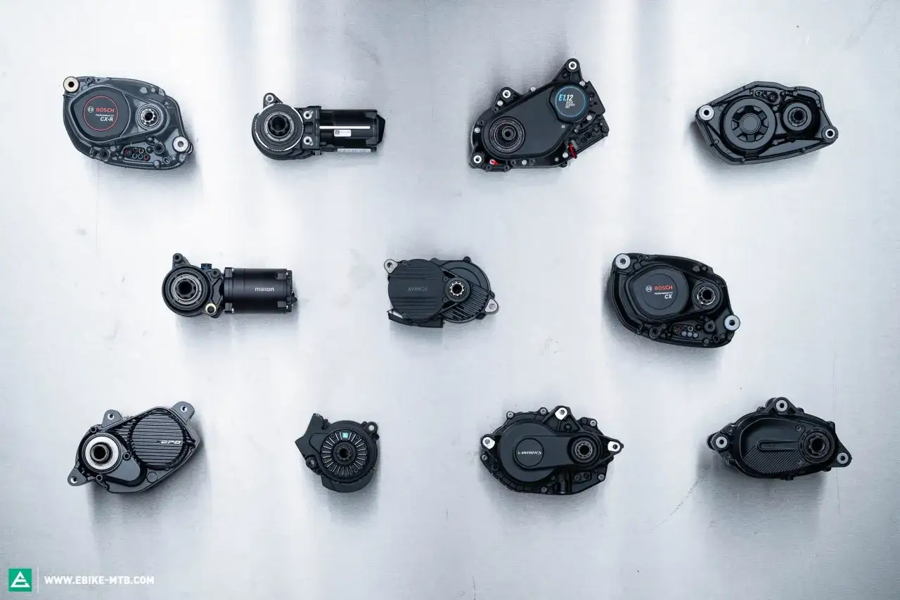 Verschiedene elektro bike motor Modelle von Bosch, Maxon, Avinox und Mahle liegen auf einer metallischen Oberfläche.