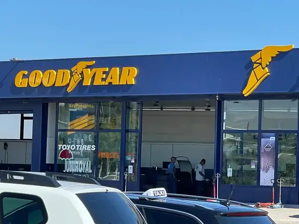 Goodyear-Werkstatt mit großen gelben Buchstaben und dem geflügelten Schuh-Logo. Hier gibt es reifen vor ort.